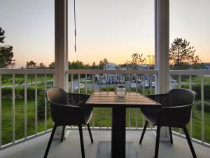 マゴグにあるChalet Tranquillité Orfordの駐車場の景色を望むバルコニー(テーブル、椅子付)