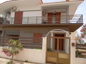 a house with a balcony with a dog on it at Vion Place Marathopoli in Marathopoli +3 photos