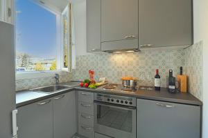 een keuken met witte kasten, een wastafel en een fornuis bij Amazing Lugano - Happy Rentals in Lugano