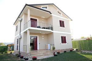 uma casa branca com uma varanda em Fly Rooms em Krujë