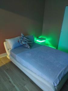 a bedroom with a bed with a green light on it at Queens chateau in Laurelton