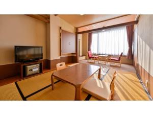 水俣市にあるYunoko Umi To Yuyake - Vacation STAY 83042vのテーブルと椅子とテレビのあるリビングルーム