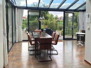 a conservatory with a table and chairs and glass doors at Pet-Friendly Coastal Getaway in Breskens