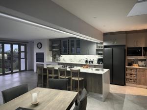 a kitchen with stainless steel appliances and wooden cabinets at Casa de Santos - Bougain Villa in Mossel Bay