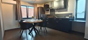 a kitchen with a table and chairs in a kitchen at Het Mezennest in Zonhoven