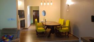 a dining room with a table and yellow chairs at Tamwe ltd Airbnb &studios in Meru +4 photos