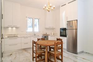 a kitchen with a wooden table and a refrigerator at Variea Vista in Mytilene
