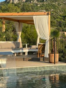 a pergola next to a swimming pool next to a house at Masarya house in Marmaris