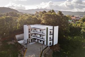 un edificio blanco en la cima de una colina con árboles en Elithe Hotel, en La Esperanza