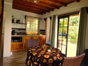 a kitchen with a table and chairs with a tablecloth on it at Arenal Sweet Cabins in Fortuna