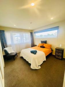 a bedroom with a large bed and a chair at City Town House in Christchurch