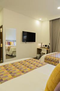 Una habitación de hotel con dos camas y un televisor de pantalla plana. en Elithe Hotel, en La Esperanza 21 fotos más