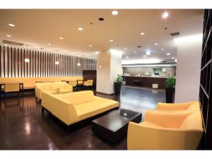 a lobby with yellow chairs and tables and a bar at Smile Hotel Sendai Kokubuncho - Vacation STAY 77694v in Sendai