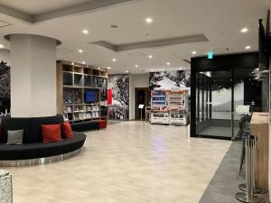 a store lobby with a black couch in the middle at Smile Hotel Hiroshima - Vacation STAY 77672v in Hiroshima