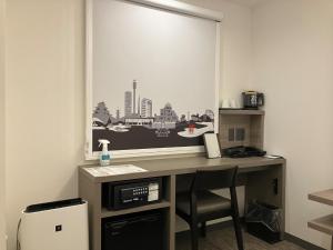 a desk in a room with a picture on the wall at Smile Hotel Hiroshima - Vacation STAY 77672v in Hiroshima