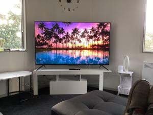 sala de estar con TV de pantalla plana en una mesa blanca en 6 Scotia, en Auckland