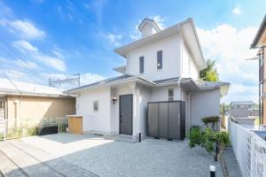 ein weißes Haus mit einem Tor in einer Einfahrt in der Unterkunft KINOTOMI - Vacation STAY 19643 in Ōtsu