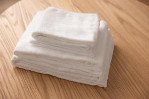 drei weiße Handtücher auf einem Holztisch gestapelt in der Unterkunft KINOTOMI - Vacation STAY 19643 in Ōtsu + 47 Fotos