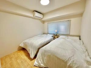 two beds in a small bedroom with a window at YADORI - Vacation STAY 81027v in Osaka