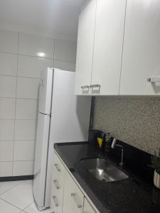 eine Küche mit Spüle und Kühlschrank in der Unterkunft Apartamento aconchegante in Baixo Guandu + 8 Fotos