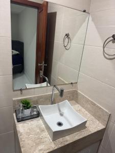ein Badezimmer mit Waschbecken und Spiegel in der Unterkunft Apartamento aconchegante in Baixo Guandu