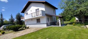 a white house with a balcony and a yard at Villa Doku in Valjiosi