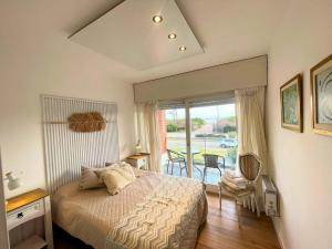 a bedroom with a bed and a view of a patio at Encantador apto frente al mar in Punta del Este