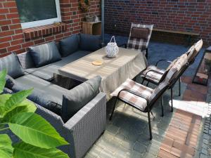 un patio con tavolo e sedie su un patio di Ferienwohnung Kerstin in Strackholt Ostfriesland- Urlaub a Großefehn 