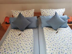 a bed with four pillows on top of it at Ferienwohnung Kerstin in Strackholt in Großefehn 