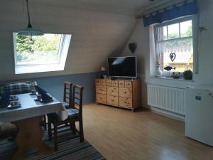 un soggiorno con un tavolo e una televisione di Ferienwohnung Kerstin in Strackholt Ostfriesland- Urlaub a Großefehn  Altre 25 foto
