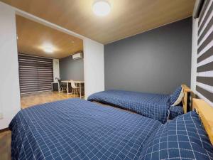 a bedroom with two beds and a dining room at Sakura Kan - Vacation STAY 19678 in Sapporo