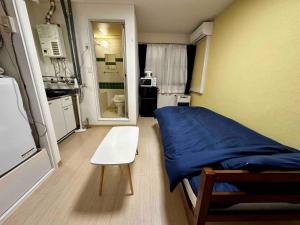 a small room with a bed and a white chair at Coop Sunlight - Vacation STAY 19686 in Sapporo
