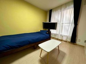 a bedroom with a bed and a tv and a chair at Coop Sunlight - Vacation STAY 19686 in Sapporo