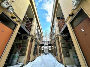 a hallway of a building with snow between two buildings at Coop Sunlight - Vacation STAY 19686 in Sapporo