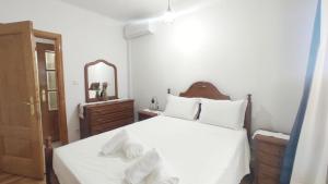 a bedroom with a bed with white sheets and a mirror at A&B Apartments - Afonso in Macedo de Cavaleiros