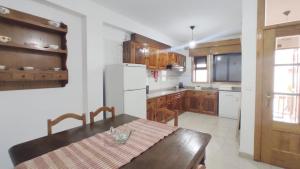 a kitchen with a table and a white refrigerator at A&B Apartments - Afonso in Macedo de Cavaleiros