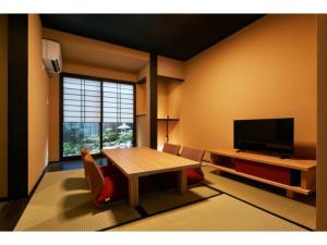 a living room with a table and a television at TSUBOMI luxury Inn Shimabara Bettei 1 - Vacation STAY 83230v in Kyoto