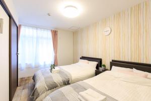 a hotel room with two beds and a window at Nagoya - House - Vacation STAY 19711 in Nagoya