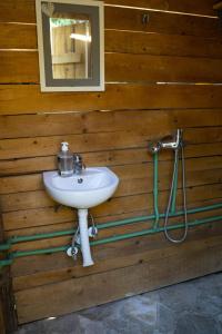 a bathroom with a sink in a wooden wall at Super cute Treehouse by the river in Mostar