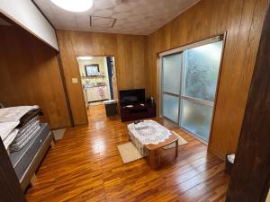 a room with a bed and a table and a television at Sea hut - Vacation STAY 83423v in Gima