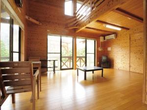 a room with a bench and a table and windows at Ume Camp Mura - Vacation STAY 88873v in Saiki