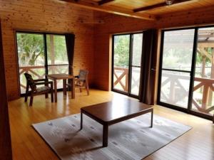 a living room with a table and chairs and windows at Ume Camp Mura - Vacation STAY 88863v in Saiki +5 photos