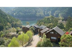 a group of houses with a lake in the background at Ume Camp Mura - Vacation STAY 88863v in Saiki