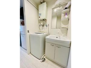 een witte badkamer met een wastafel en een toilet bij Cream Building - Vacation STAY 19747 in Sapporo +24 foto's