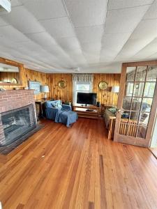 a living room with a fireplace and a tv at CAMP LINDY LIMIT 7 cottage in North Sebago +13 photos