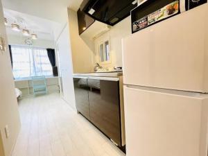 een keuken met een witte koelkast en een spoelbak bij Cream Building - Vacation STAY 19747 in Sapporo