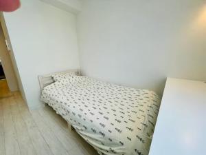 een klein bed in een slaapkamer met een witte muur bij Cream Building - Vacation STAY 19747 in Sapporo
