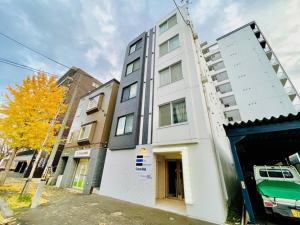 een hoog wit gebouw aan een stadsstraat bij Cream Building - Vacation STAY 19747 in Sapporo