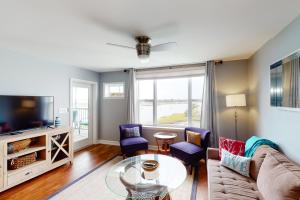 a living room with a couch and a tv at Turn of River 4F in Folly Beach