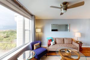 a living room with a couch and a large window at Turn of River 4F in Folly Beach +29 photos